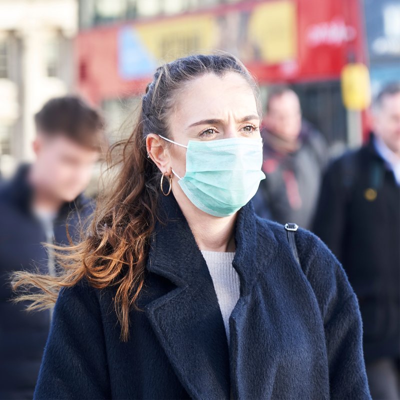 Woman wearing a mask in a crowded public place